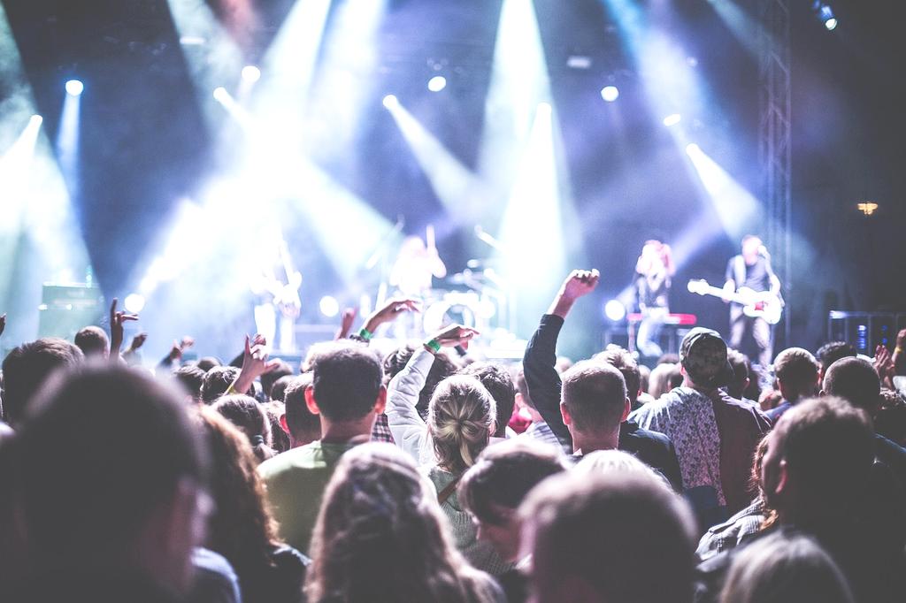 Vibrant concert stage with colorful lights and enthusiastic crowd